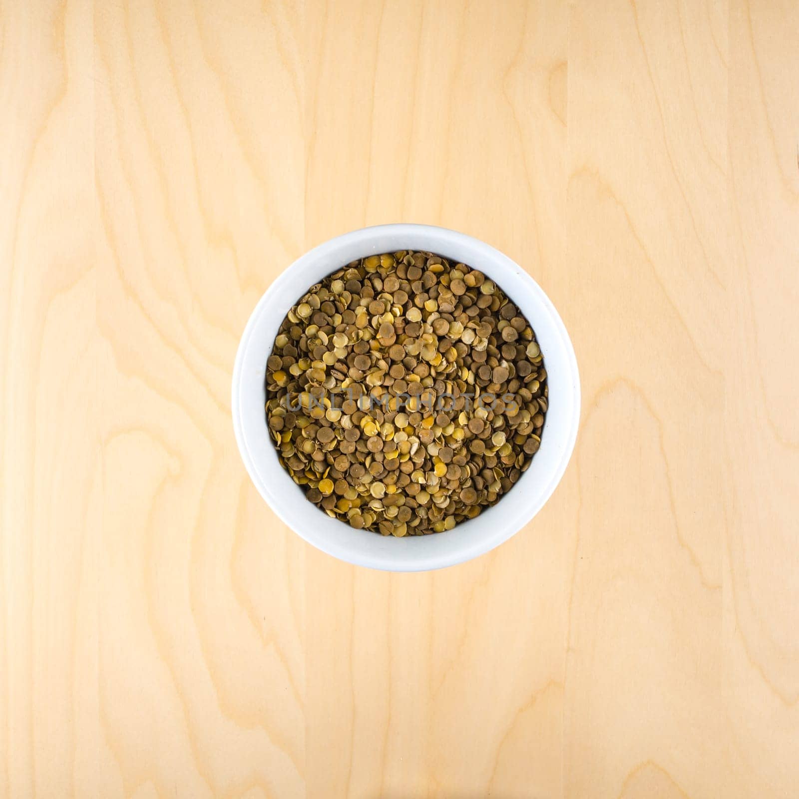 Heart shaped from raw dry brown lentils in cup, top view, square composition, food preparation, copy space, healthy lifestyle, eating legumes