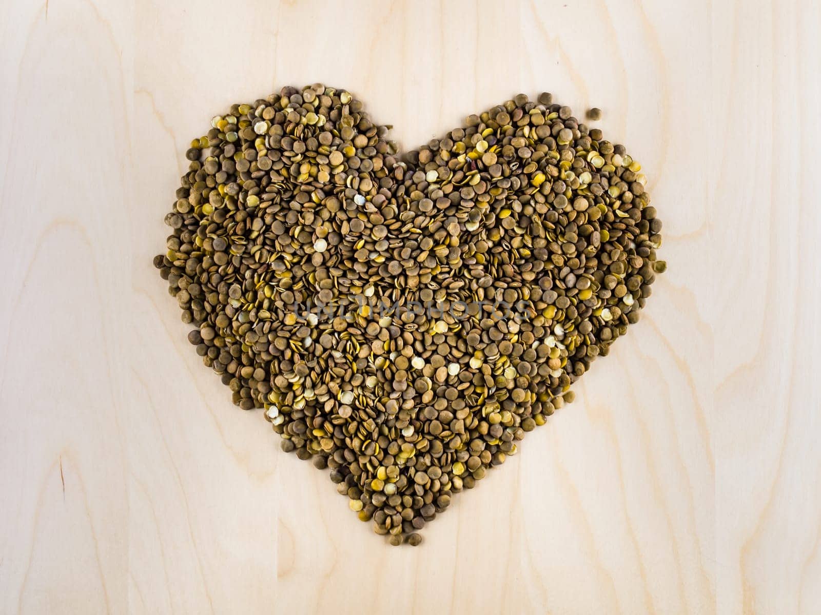 Heart shaped from raw dry brown lentils in cup, top view, square composition, food preparation, copy space, healthy lifestyle, eating legumes