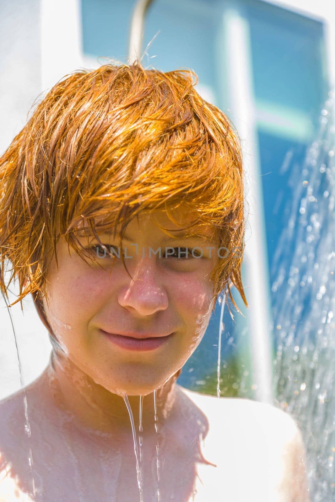child has a refreshing shower in the garden