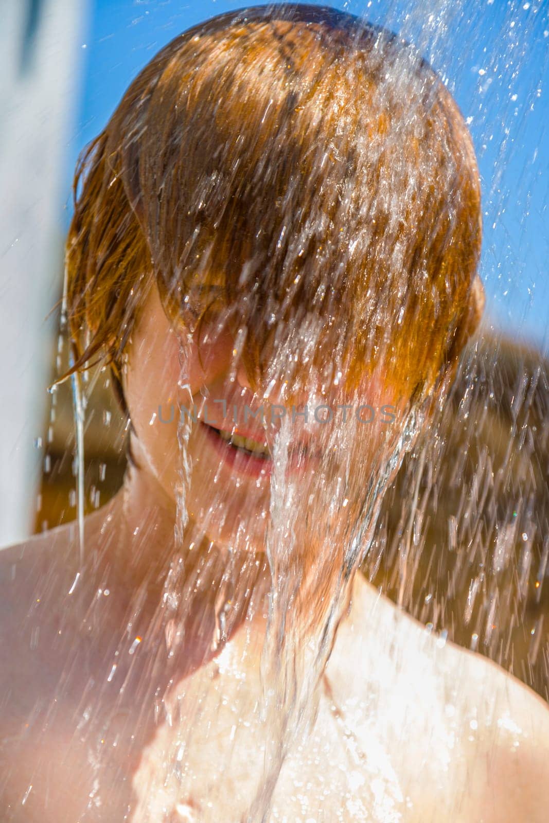 child has a refreshing shower in the garden