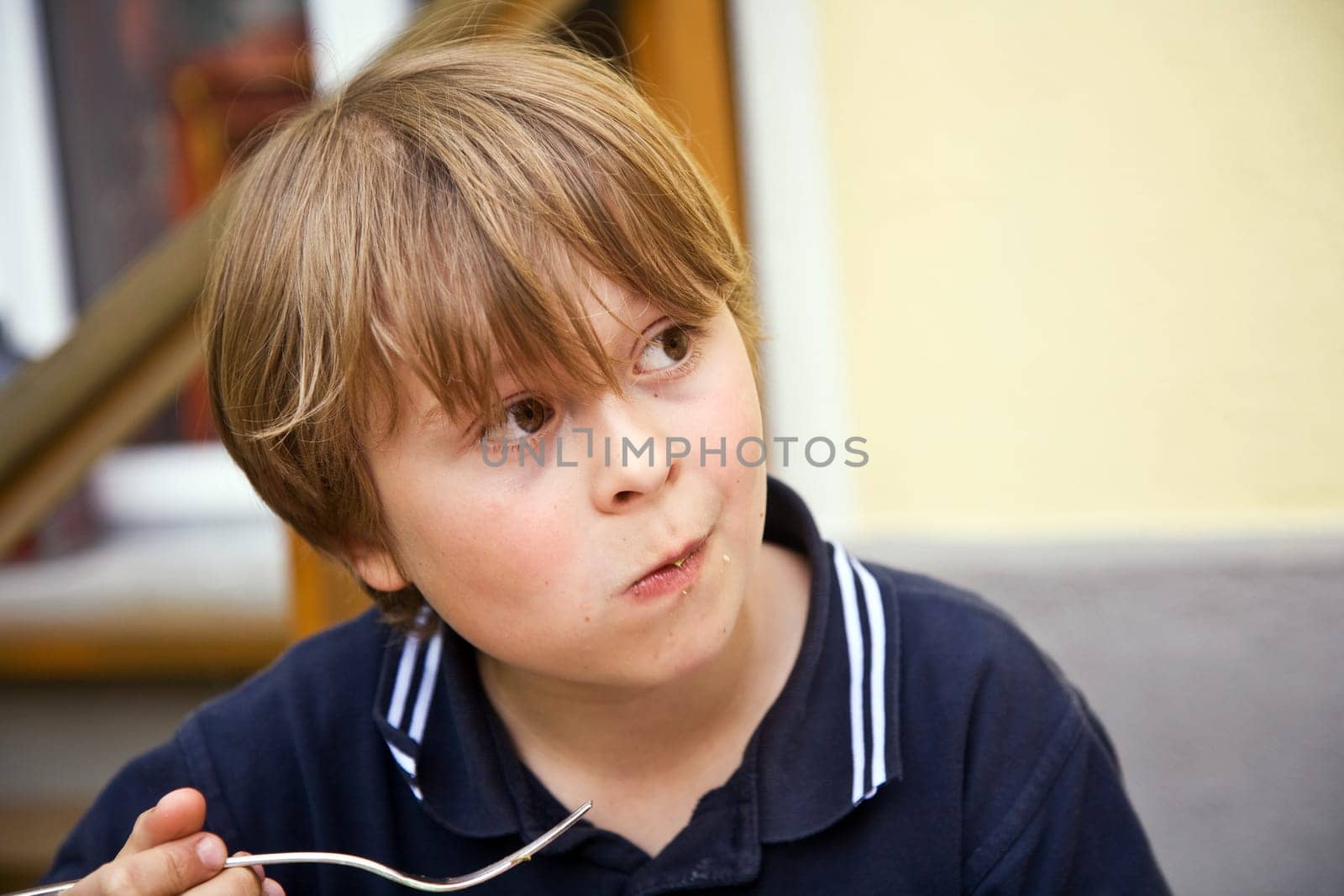 eating boy is looking astonished and interested