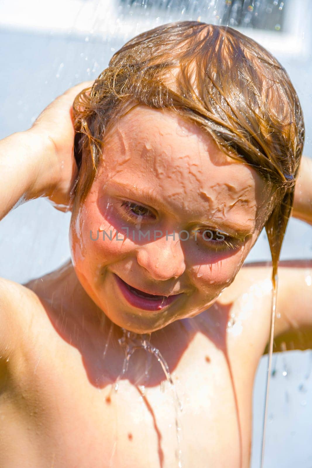 child has a refreshing shower in the garden
