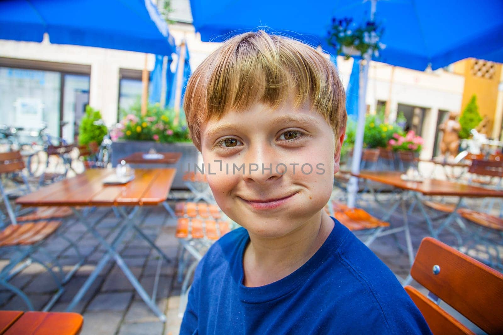 cute smiling child eats and has joy in the outdoor restaurant