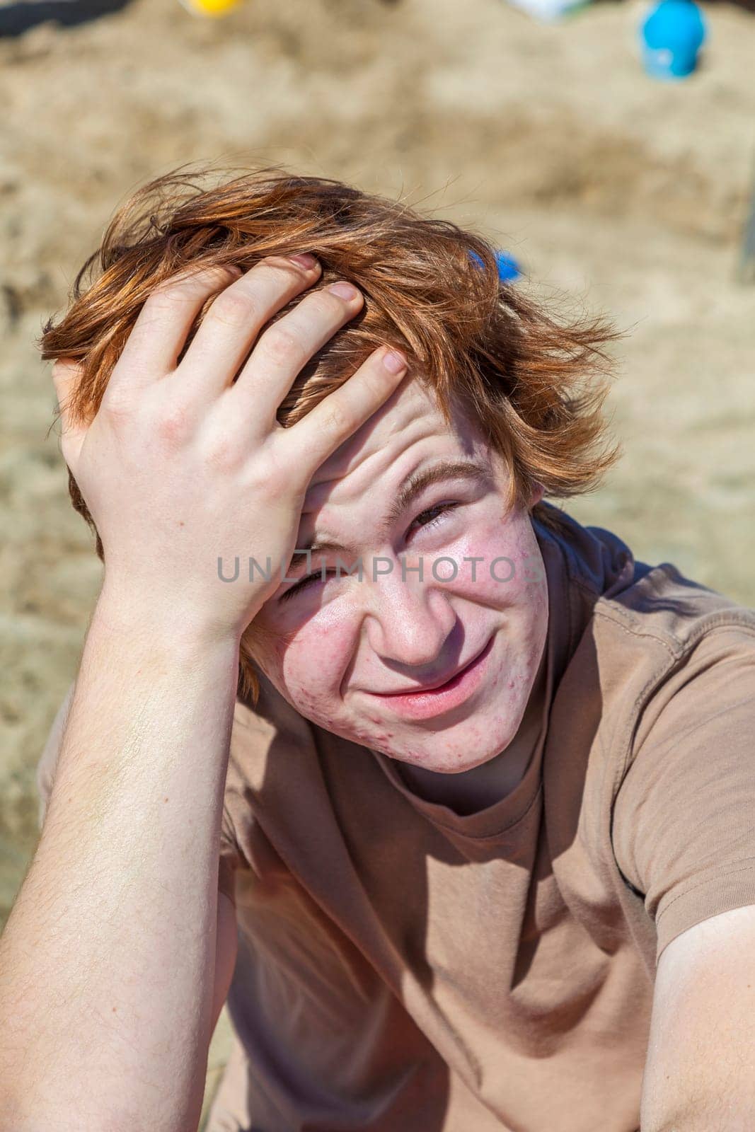 portrait of teenage boy with red hair at the beach