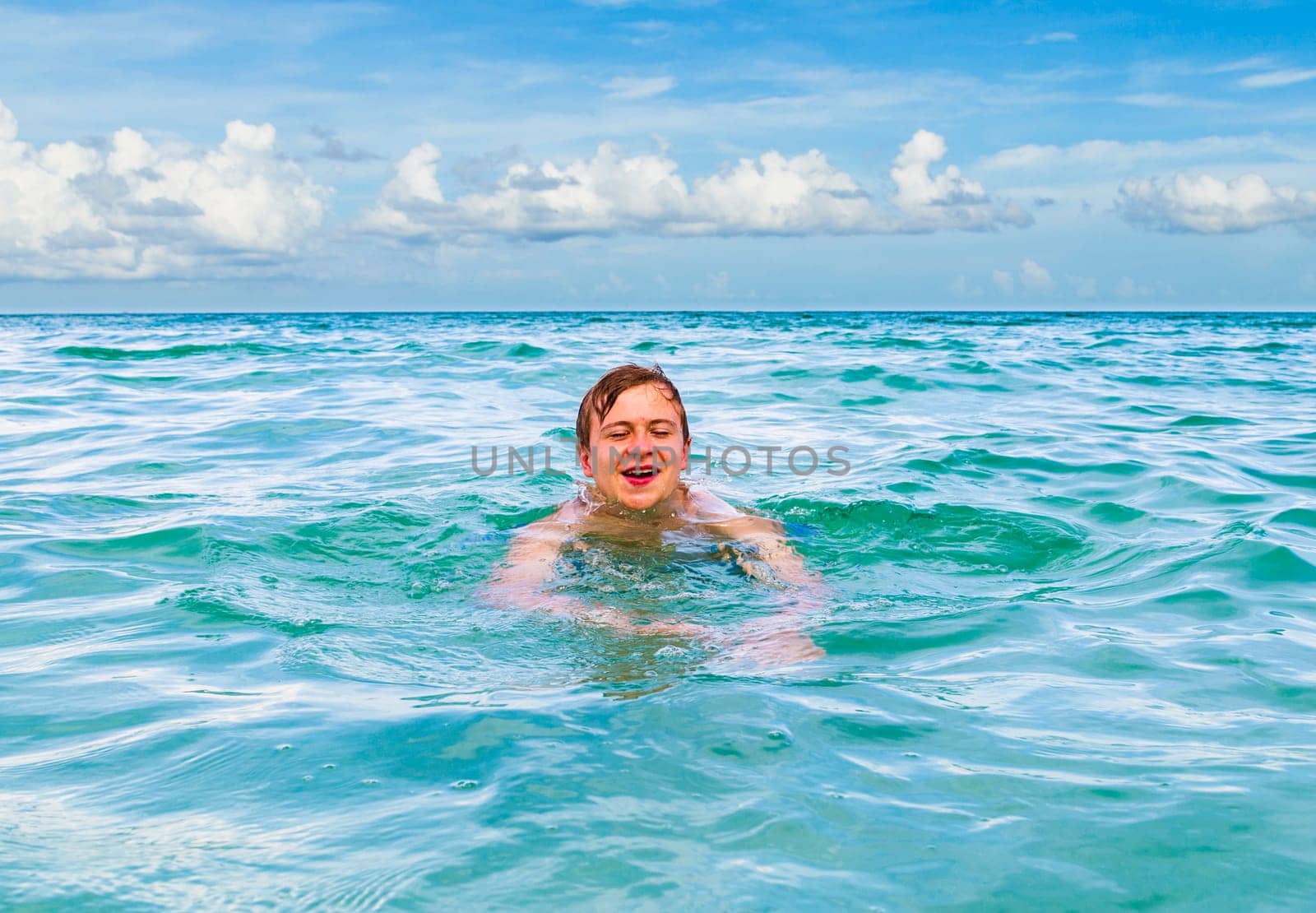 teenage boy enjoys swimming in the ocean