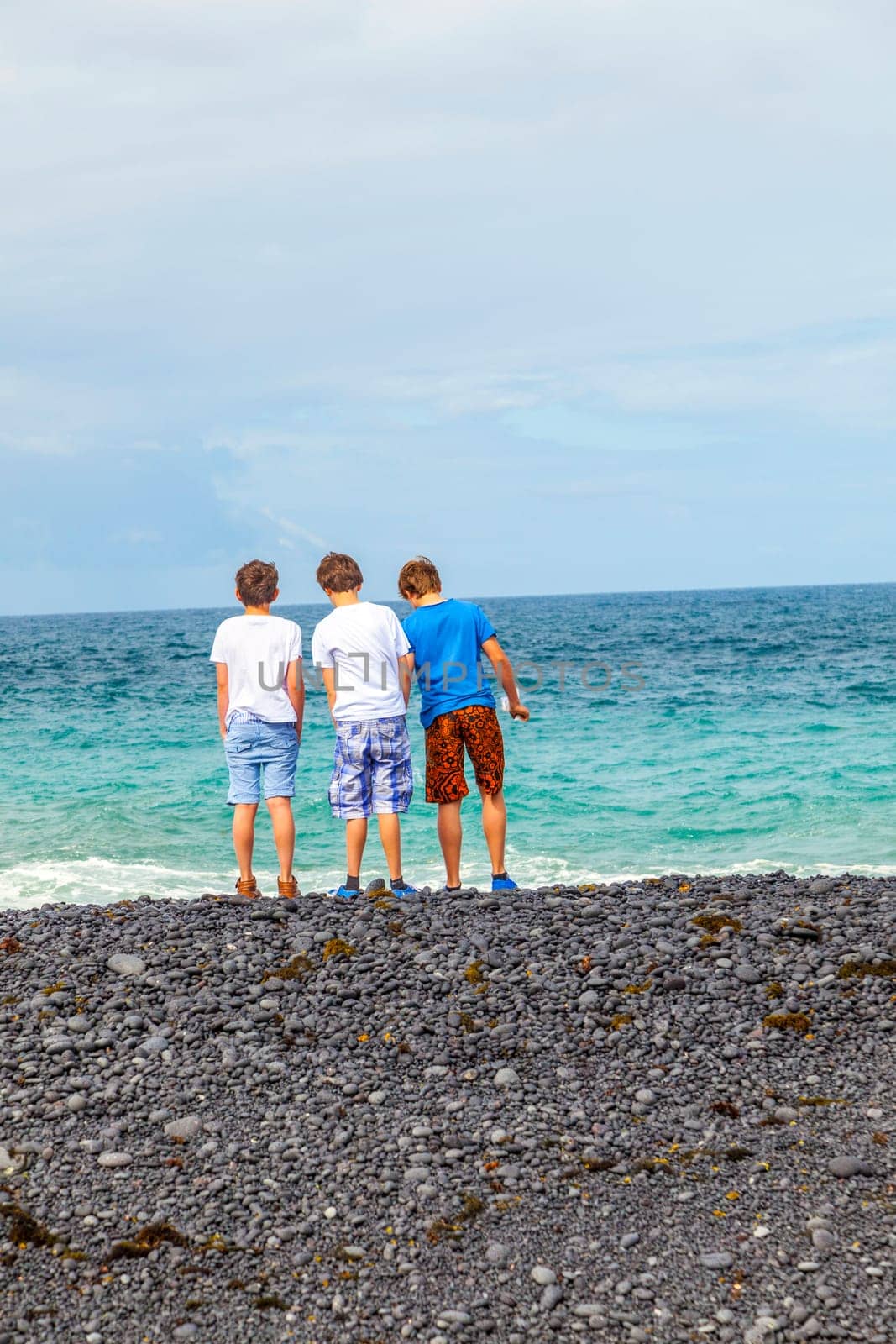 boys have fun at the black volcanic beach
