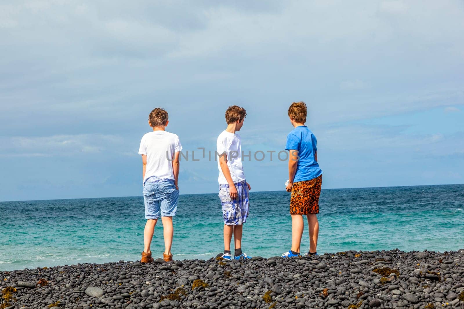 boys have fun at the black volcanic beach