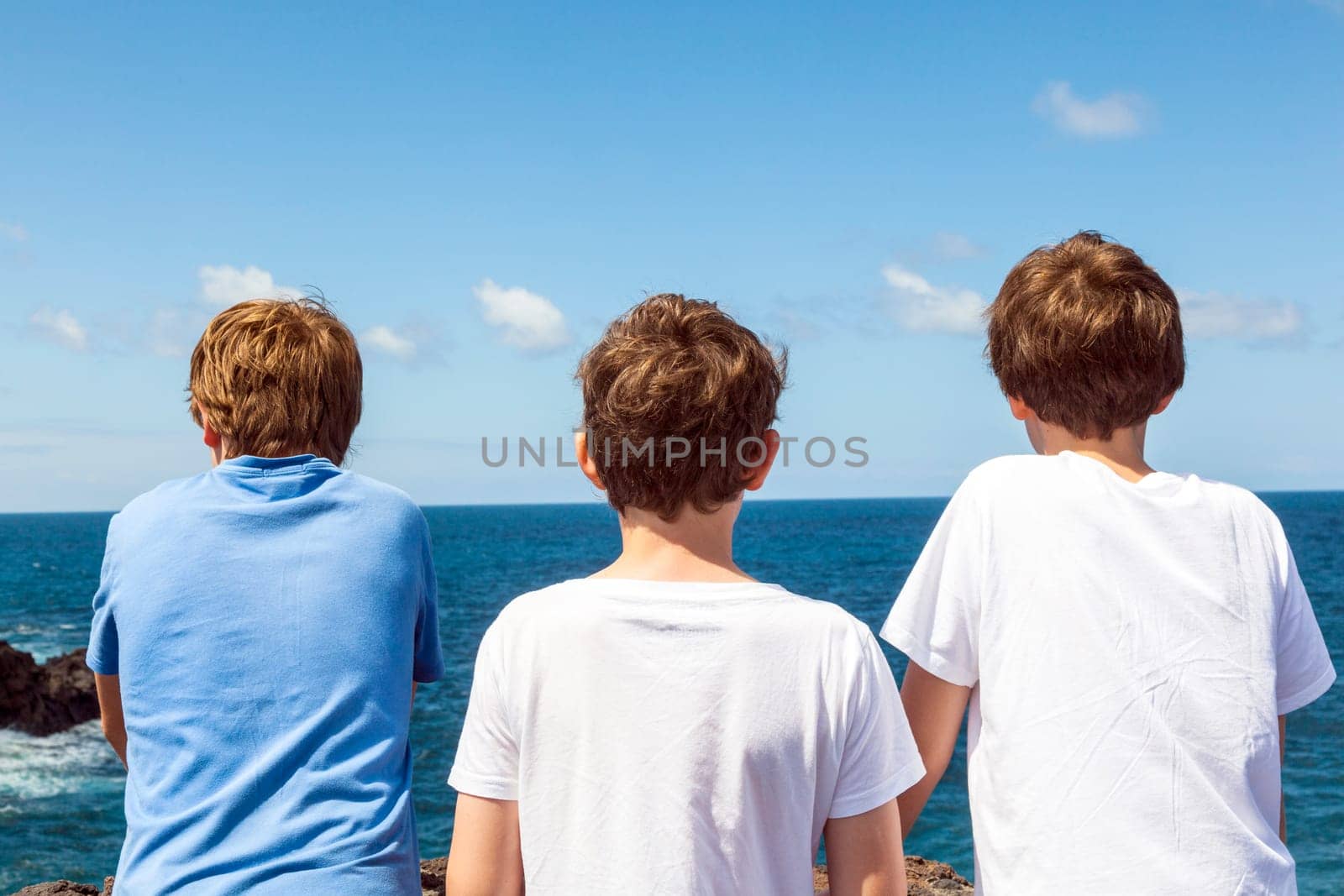 three friends watching the rocks and waves at los Hervideros in Lanzarote