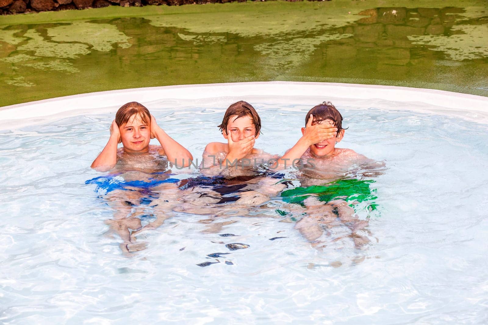 three friends in the pool imitating the three wise monkeys