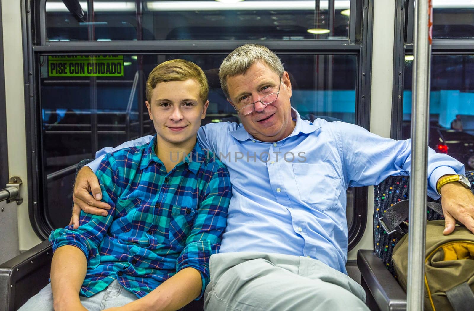 father and son at the airport bus after arrival with baggage by night