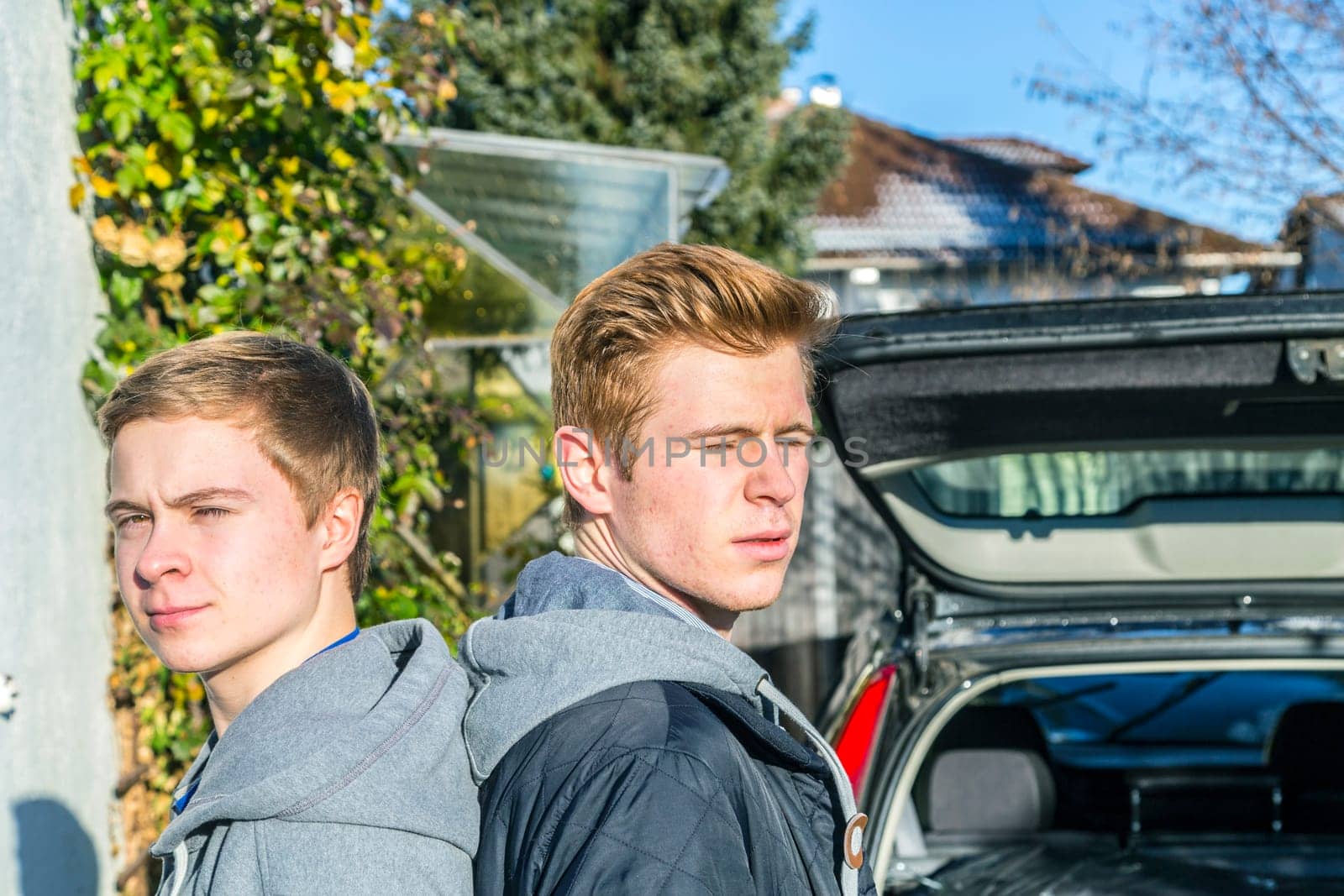 portrait of brothers in the garden with open car