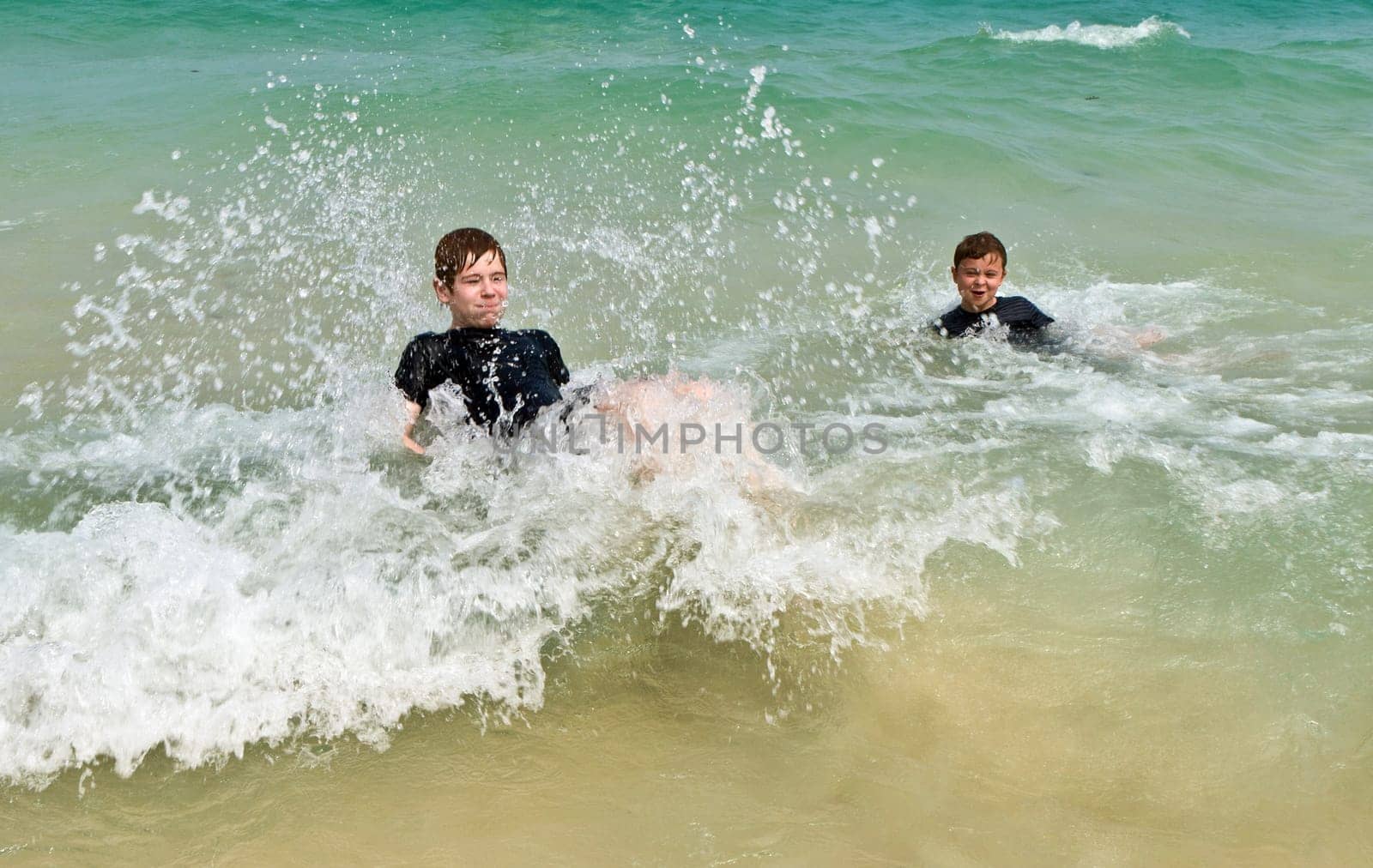 two boys having fun in the warm ocean