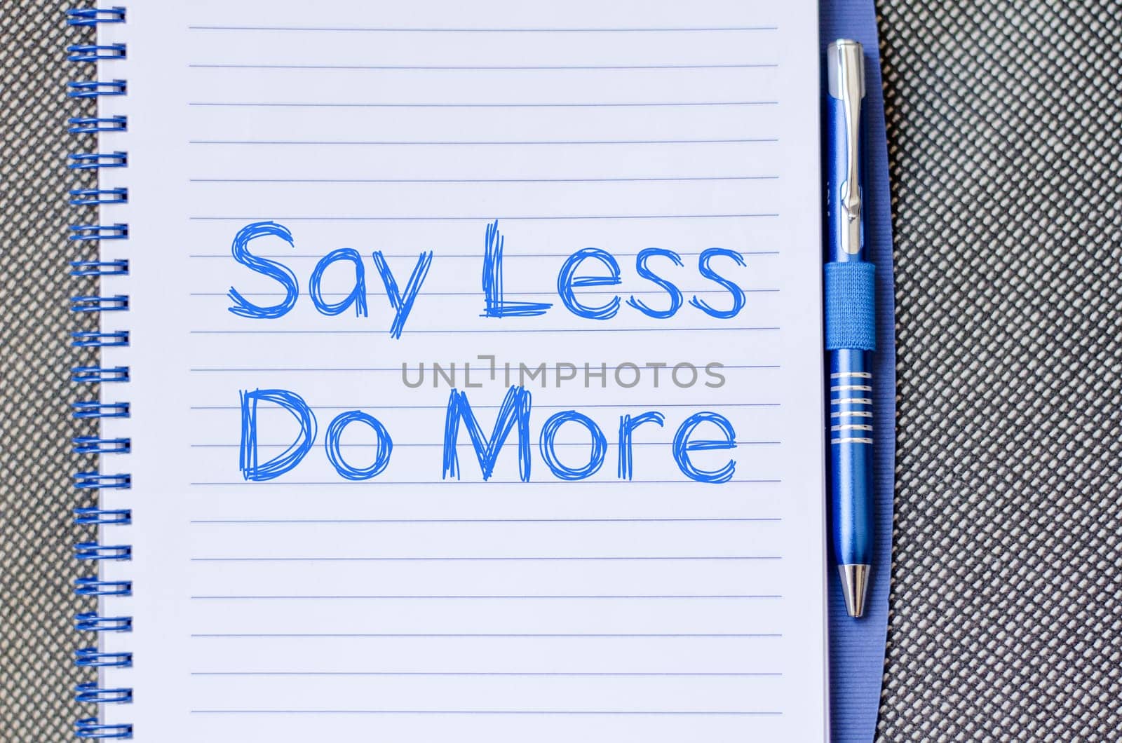 Say less do more text concept write on notebook