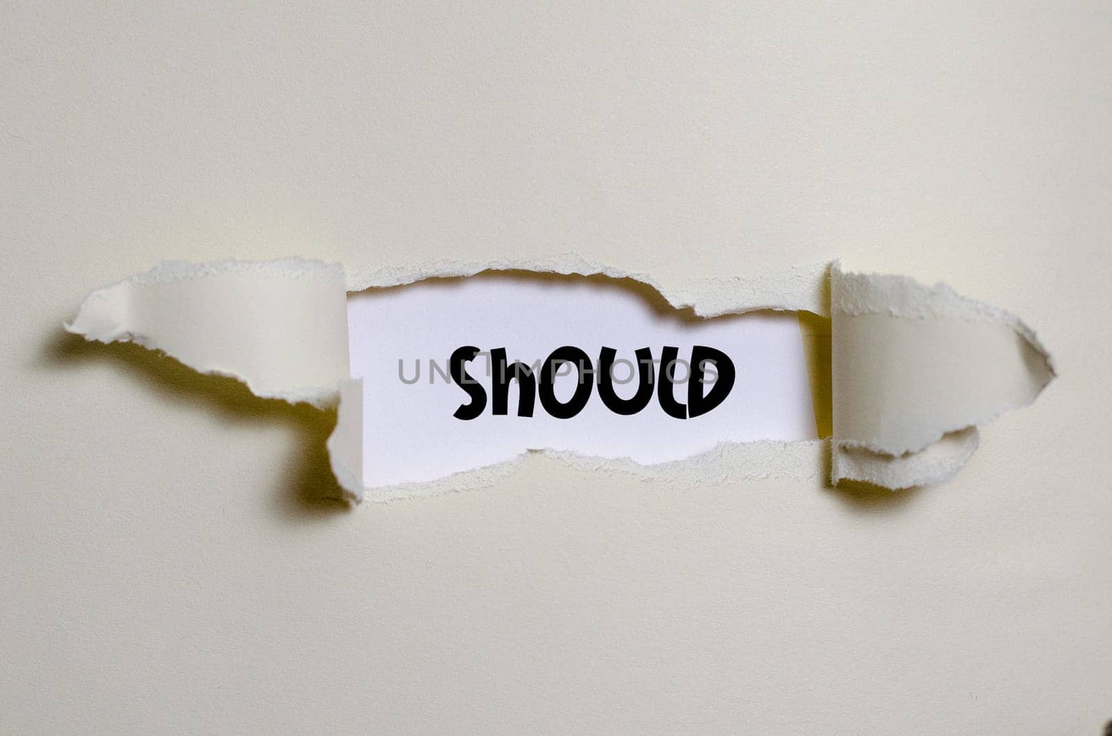 The word should appearing behind torn paper