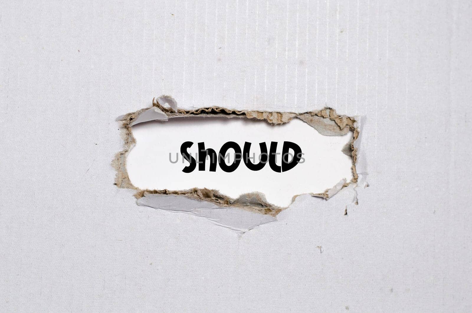 The word should appearing behind torn paper