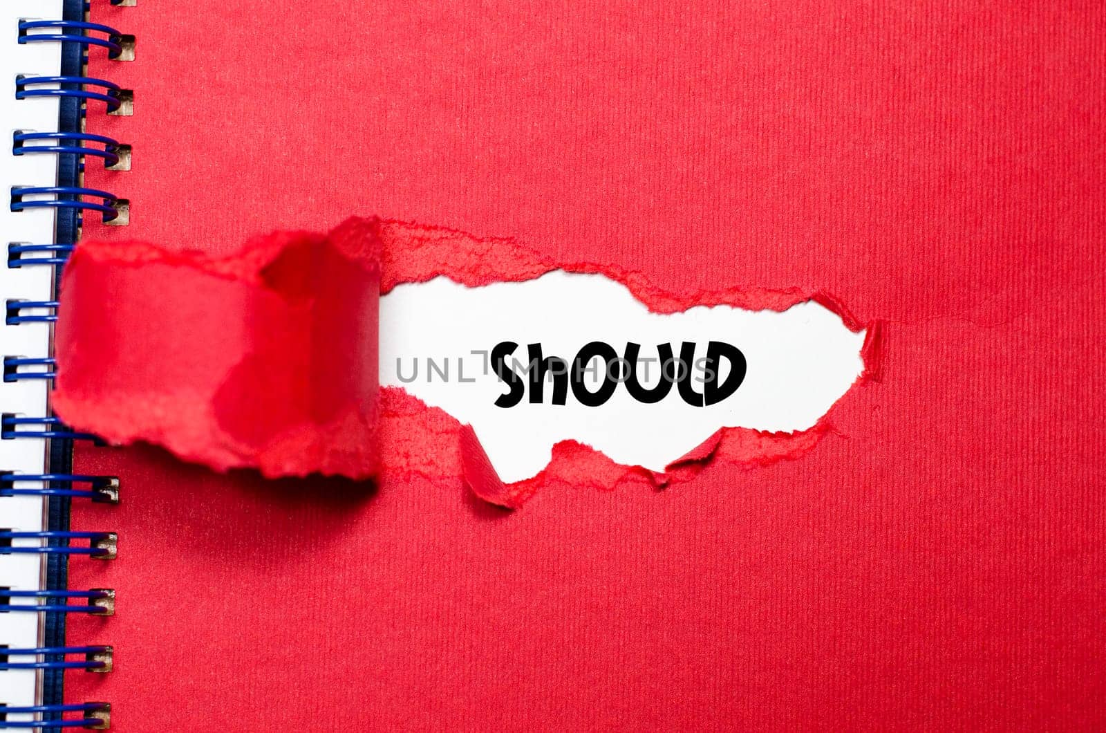 The word should appearing behind torn paper