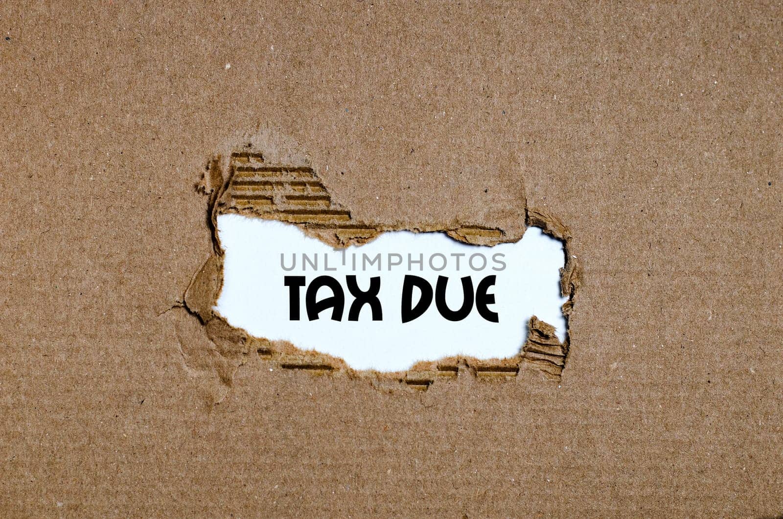 The word tax due appearing behind torn paper