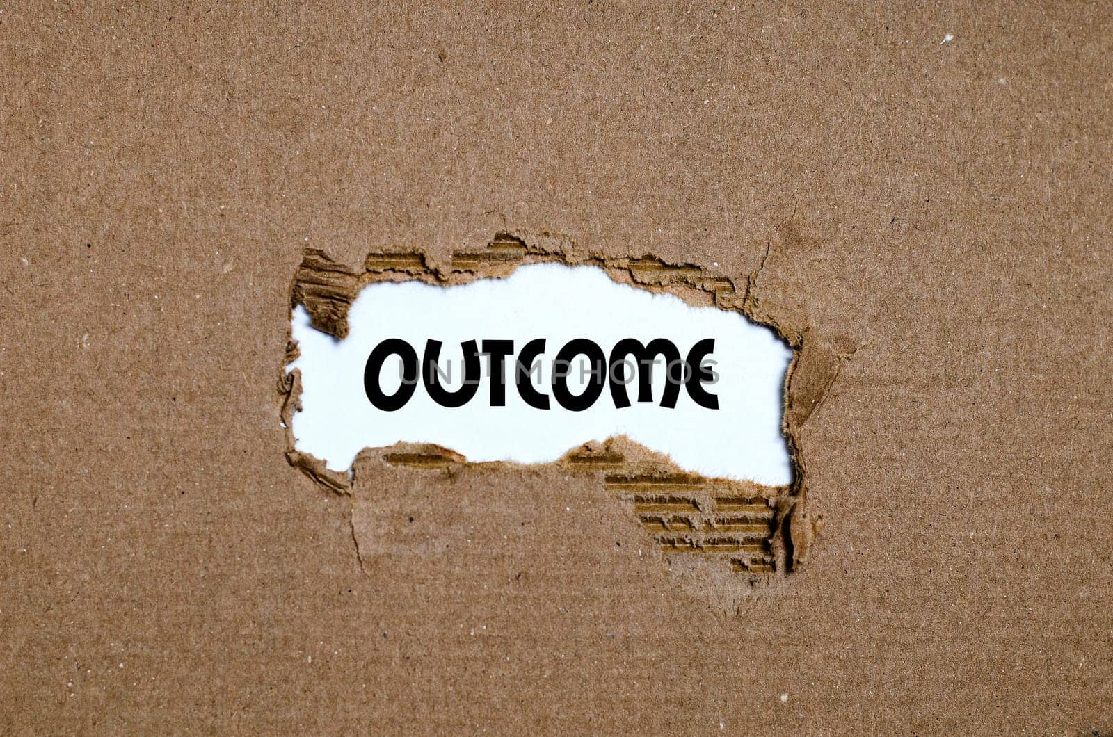 The word outcome appearing behind torn paper