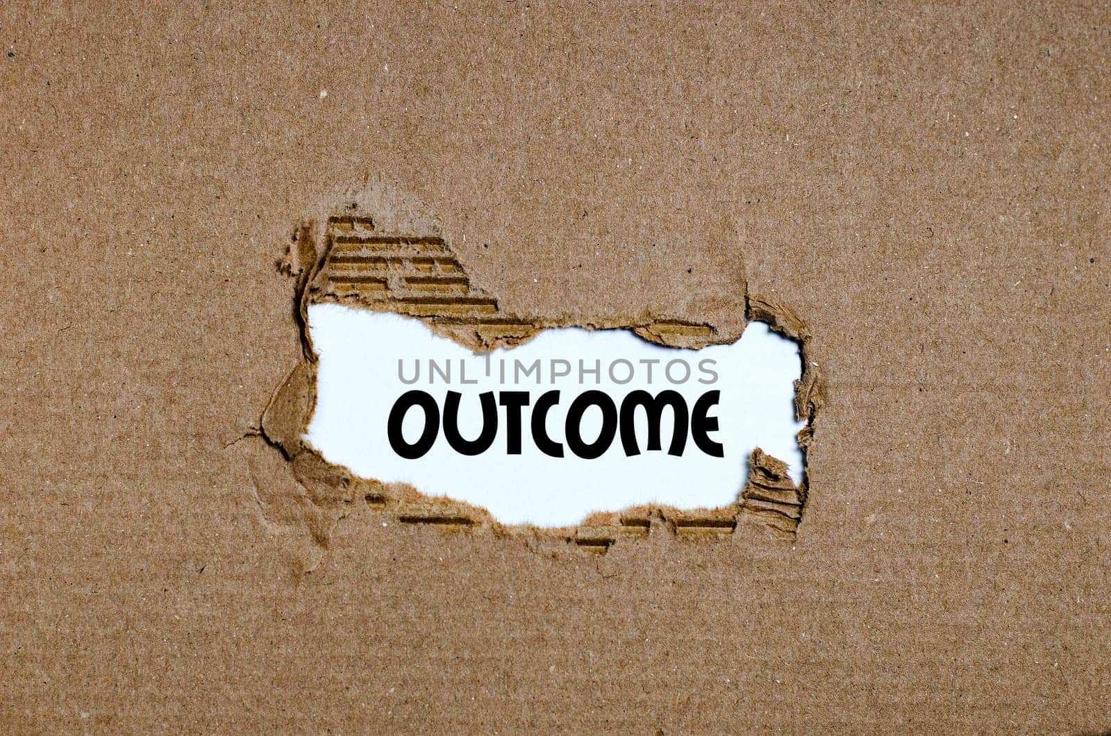 The word outcome appearing behind torn paper