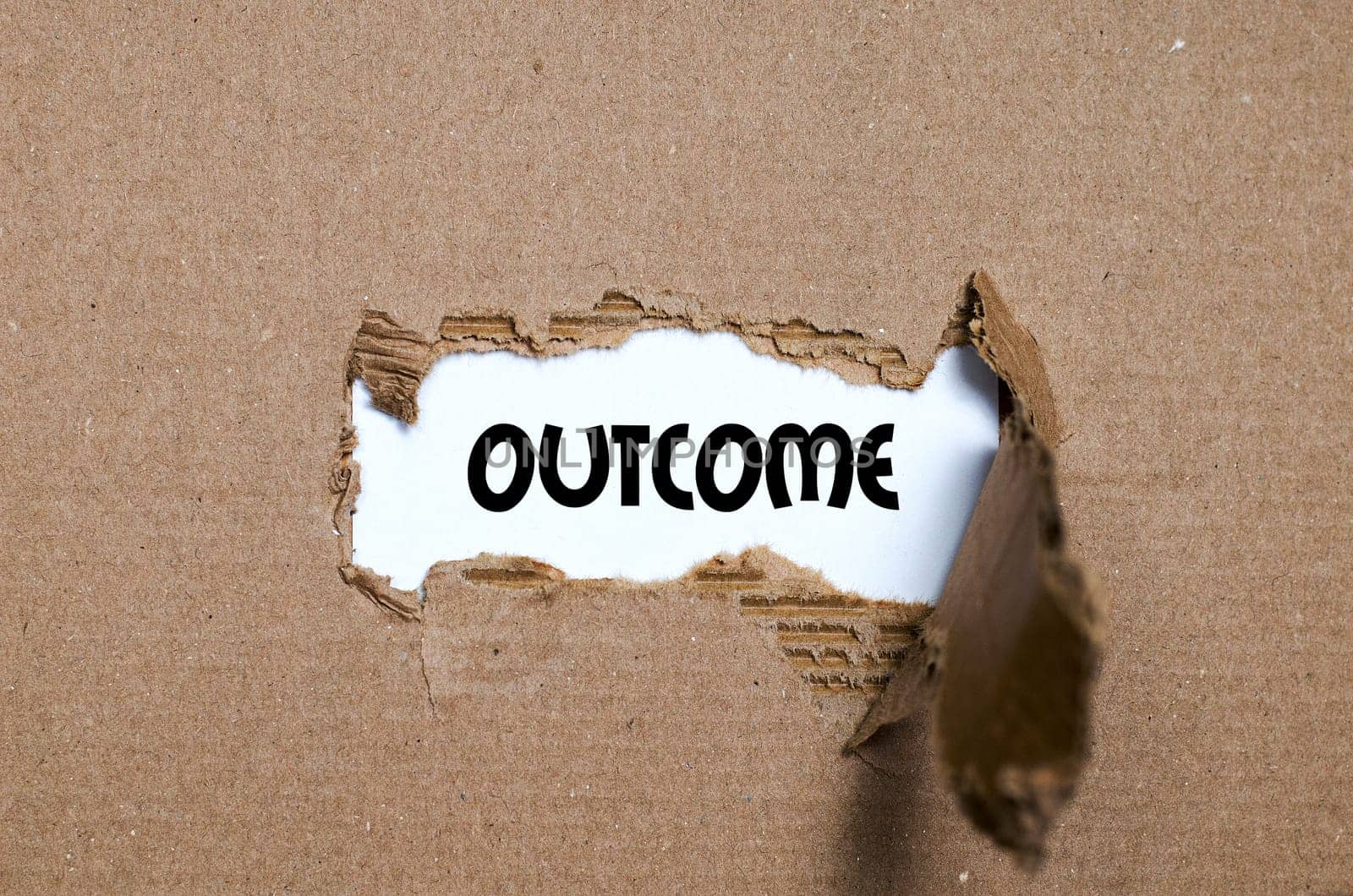 The word outcome appearing behind torn paper