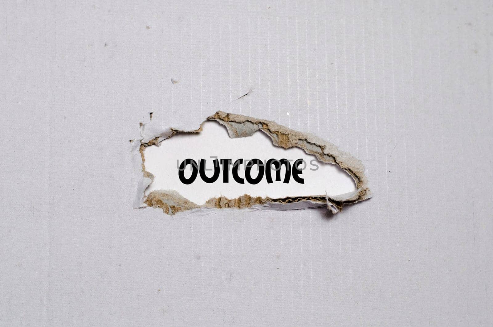 The word outcome appearing behind torn paper