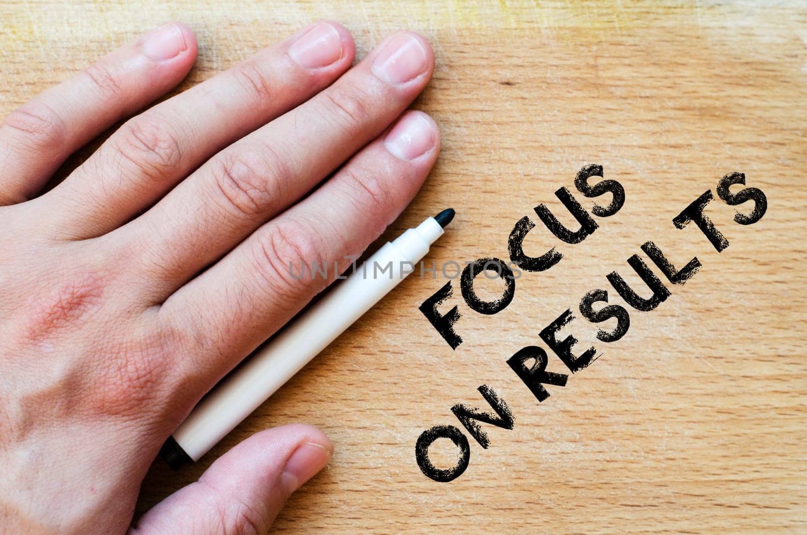Human hand over wooden background and focus on results text concept