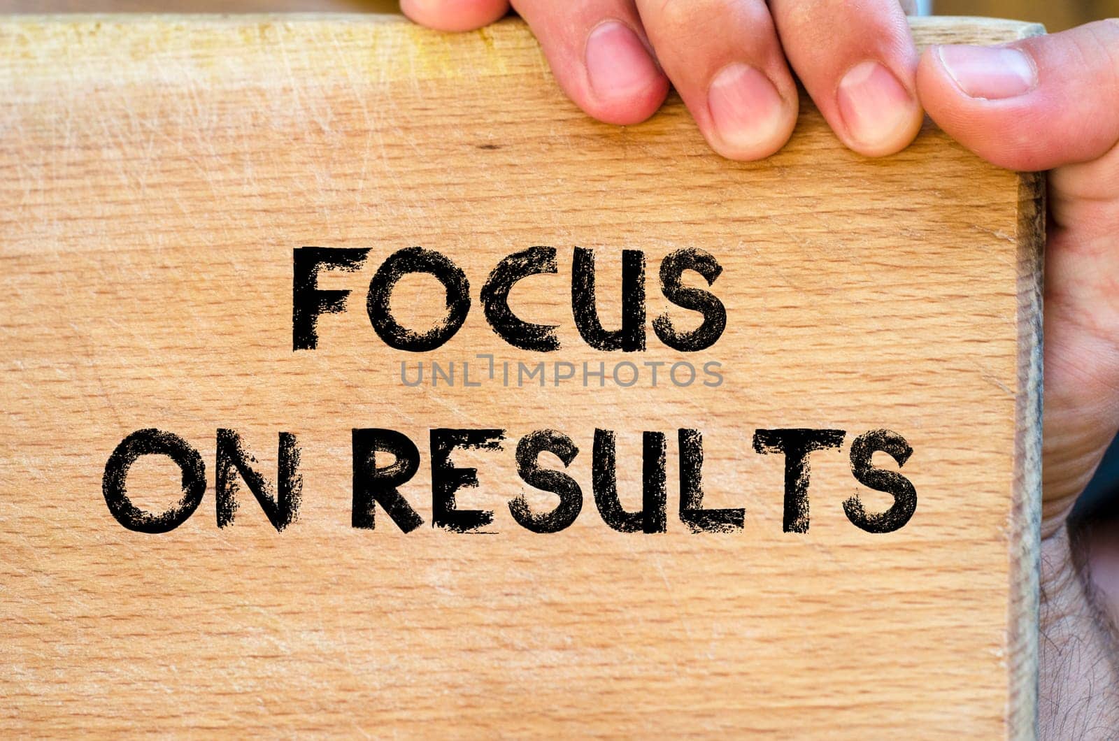 Human hand over wooden background and focus on results text concept
