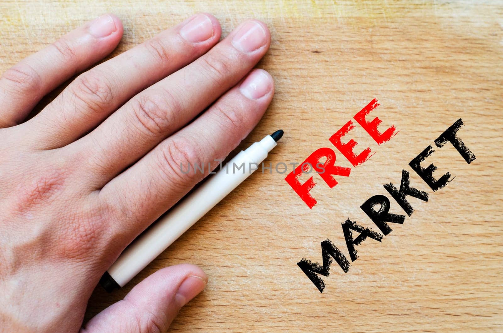 Human hand over wooden background and free market text concept