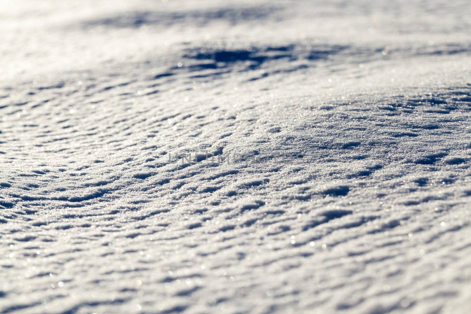 The surface of the snow in the winter season. The photo was taken close-up from the side, shallow depth of field.