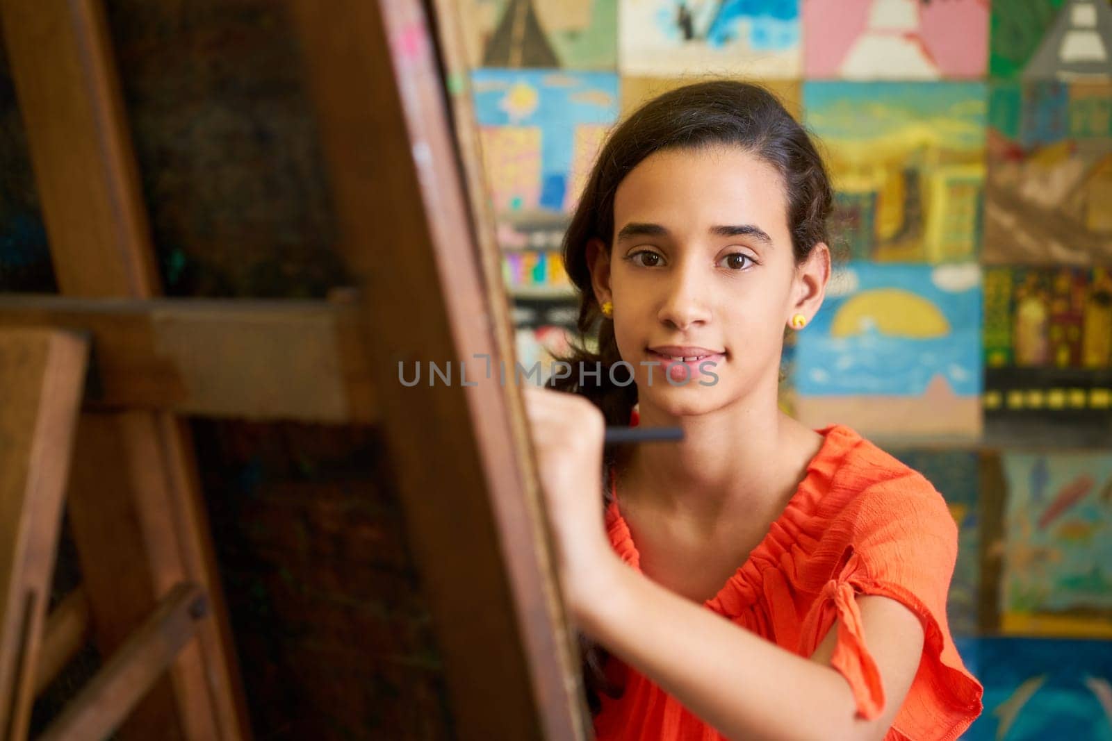 School of art, college of arts. Portrait of happy hispanic girl smiling, learning to paint and looking at camera.