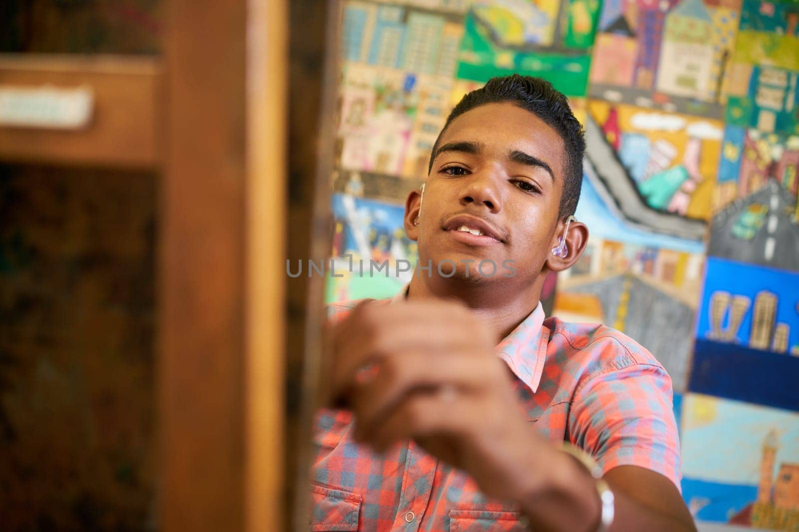 School of art, college of arts. Portrait of happy black boy smiling, learning to paint and looking at camera.