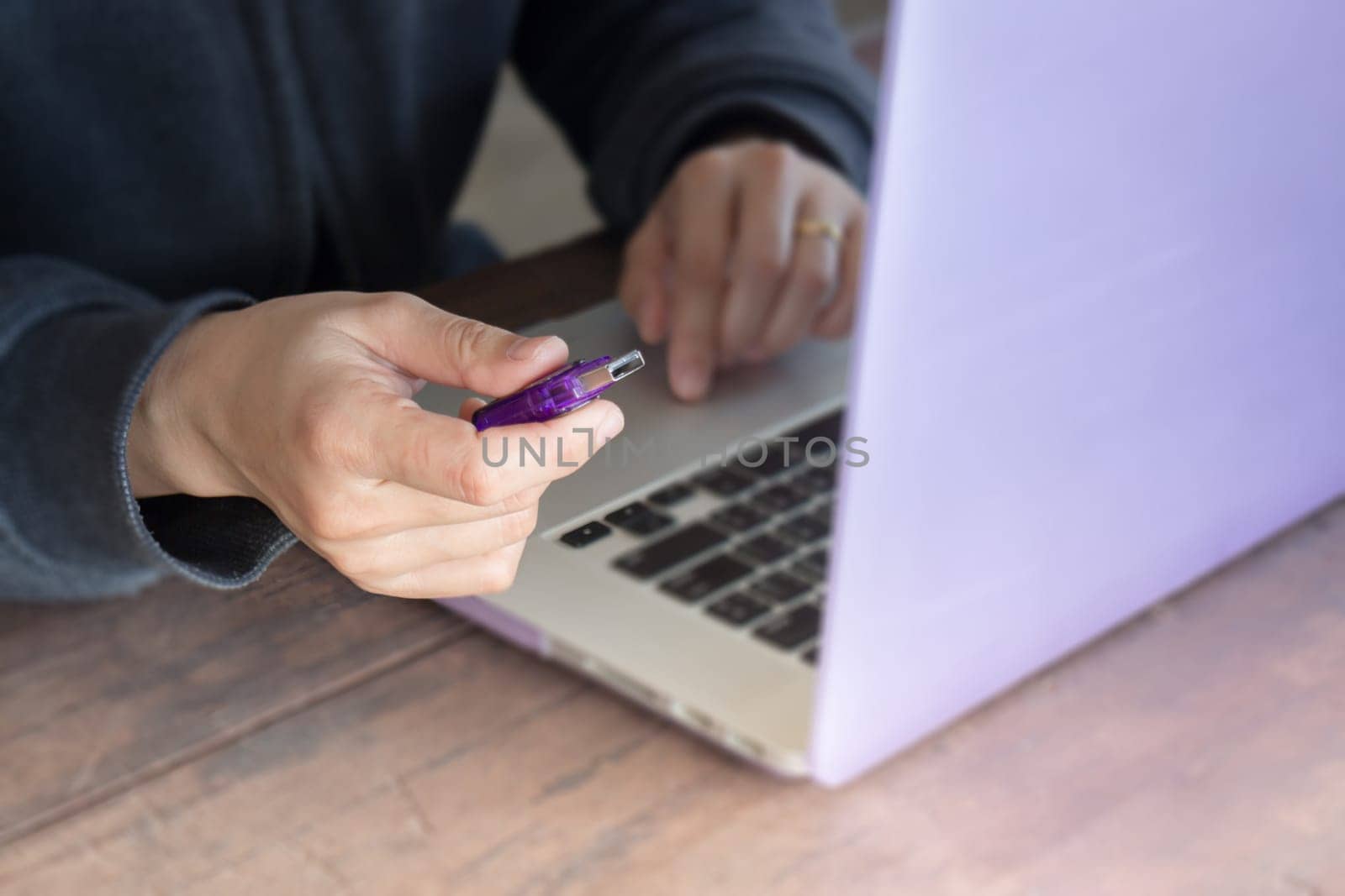 Woman using flash drive and laptop, stock photo
