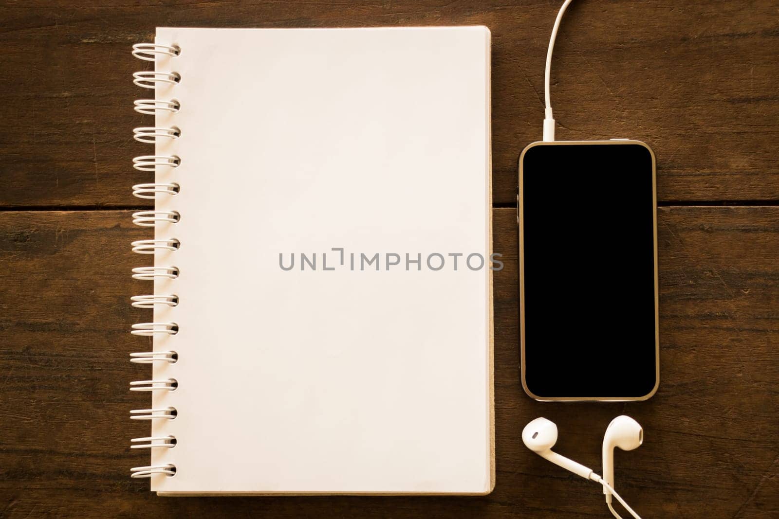 Notepaper and smart phone on wooden table, stock photo