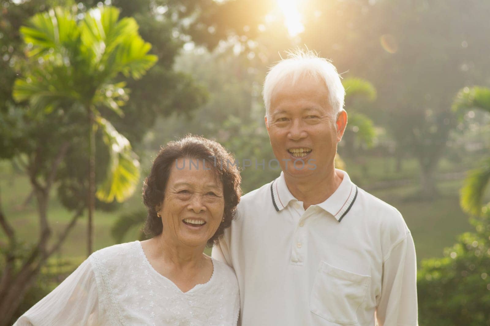 Portrait of healthy and happy Asian seniors retiree couple having activities at outdoor nature park, morning beautiful sunlight background.