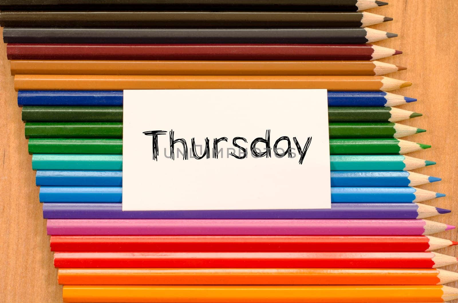 Blank white paper and colored pencils on wooden background