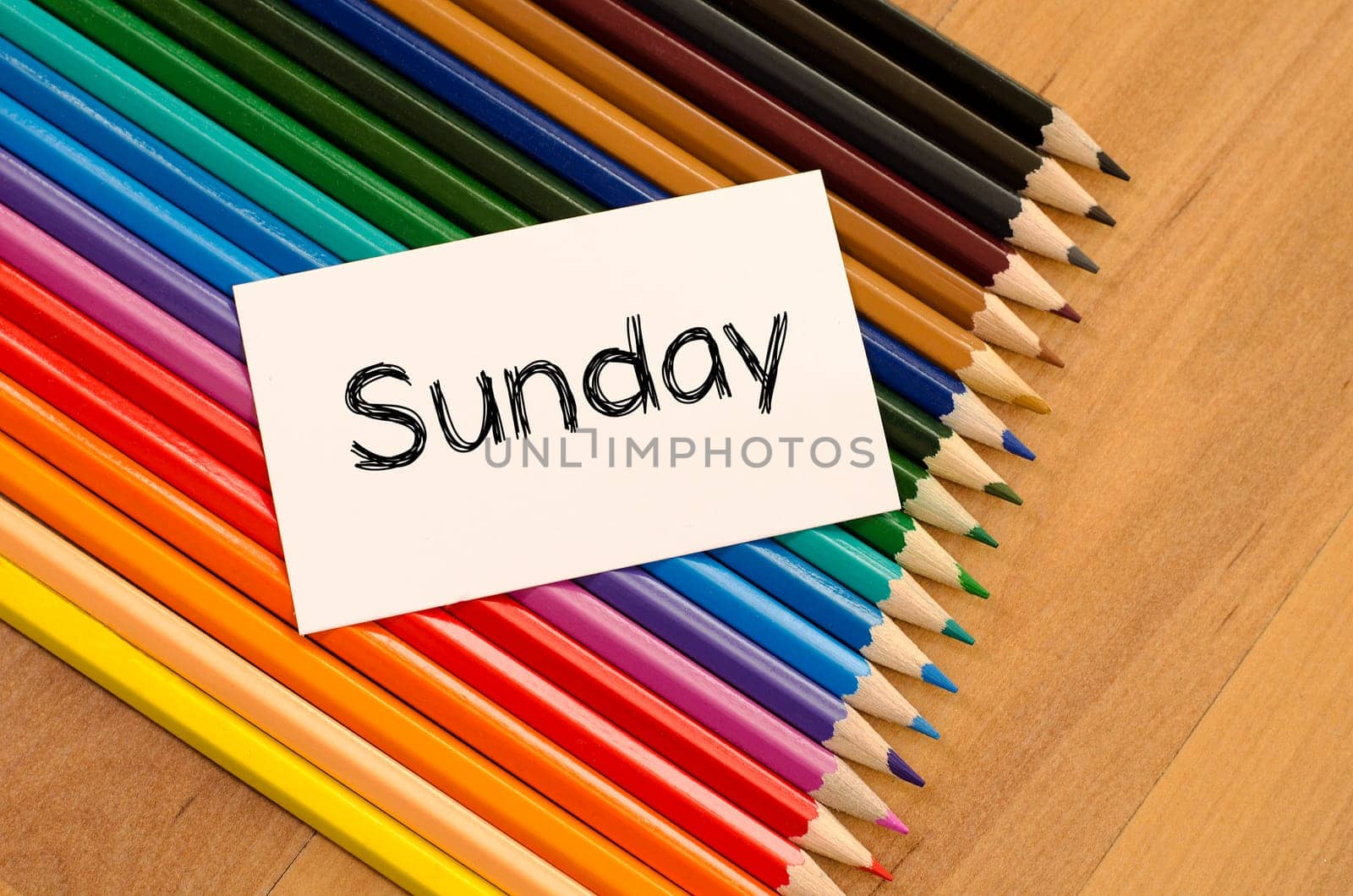 Blank white paper and colored pencils on wooden background