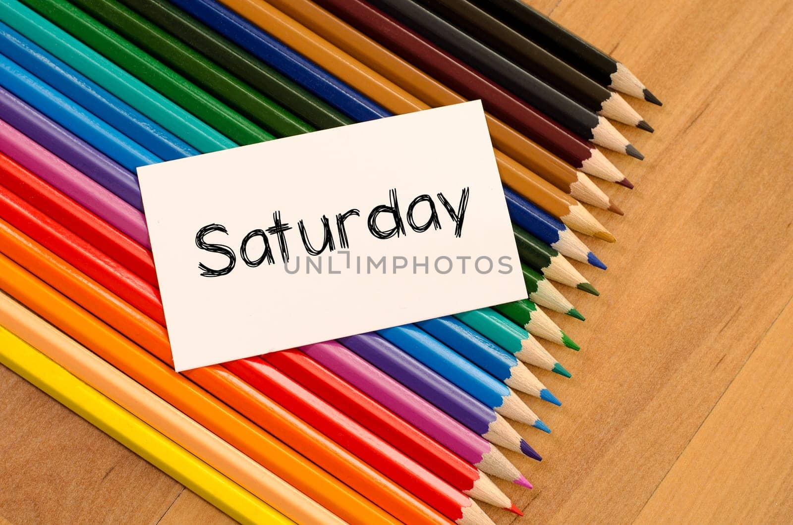 Blank white paper and colored pencils on wooden background