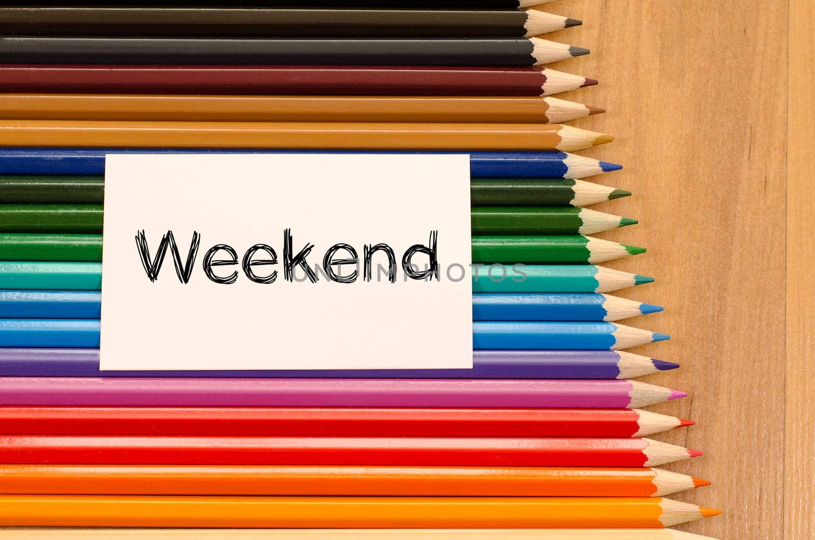 Blank white paper and colored pencils on wooden background