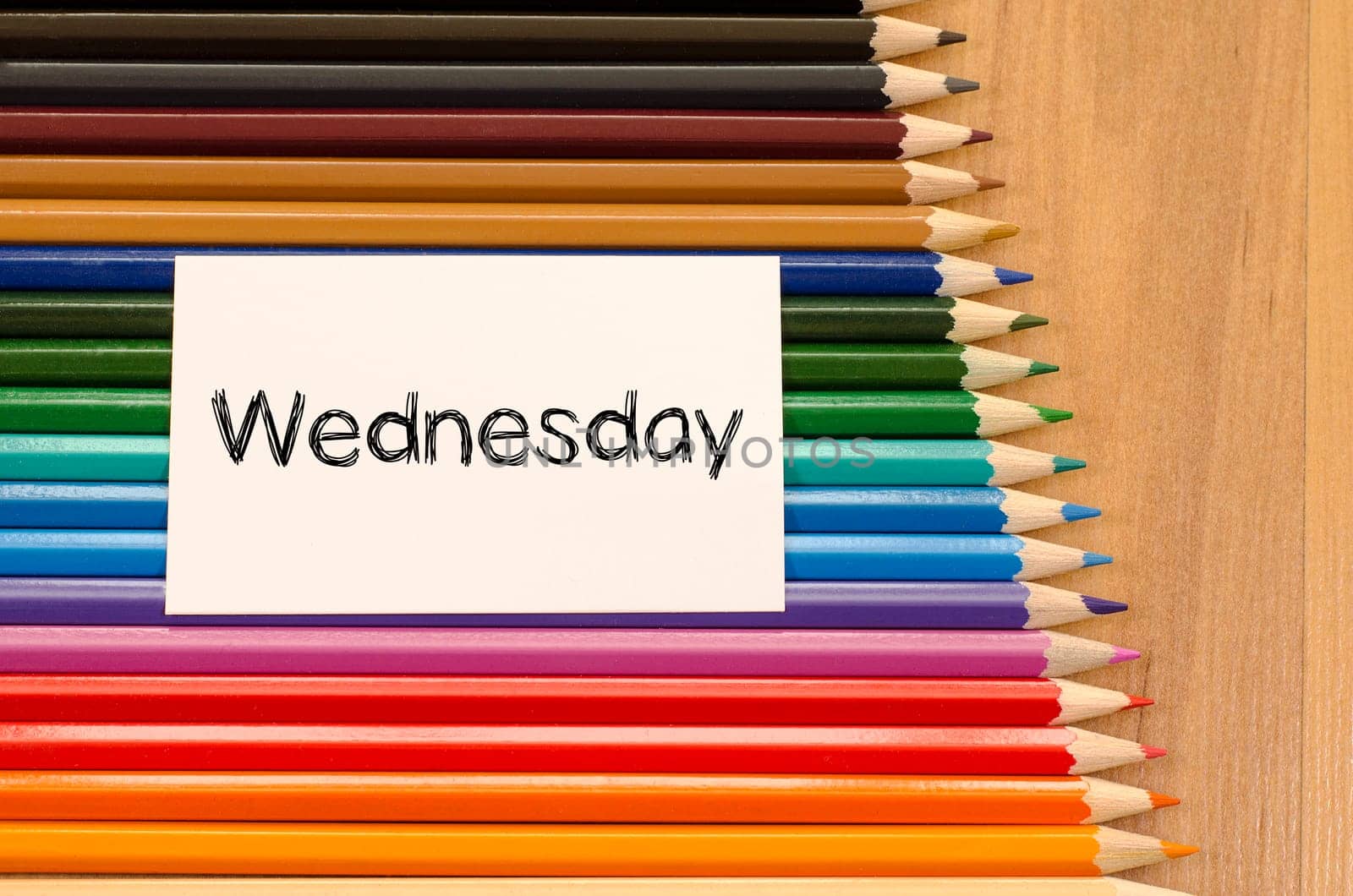 Blank white paper and colored pencils on wooden background