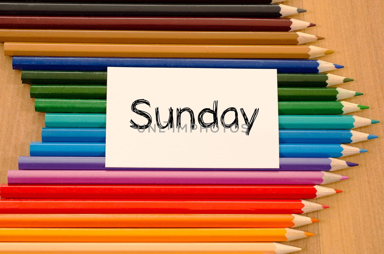 Blank white paper and colored pencils on wooden background