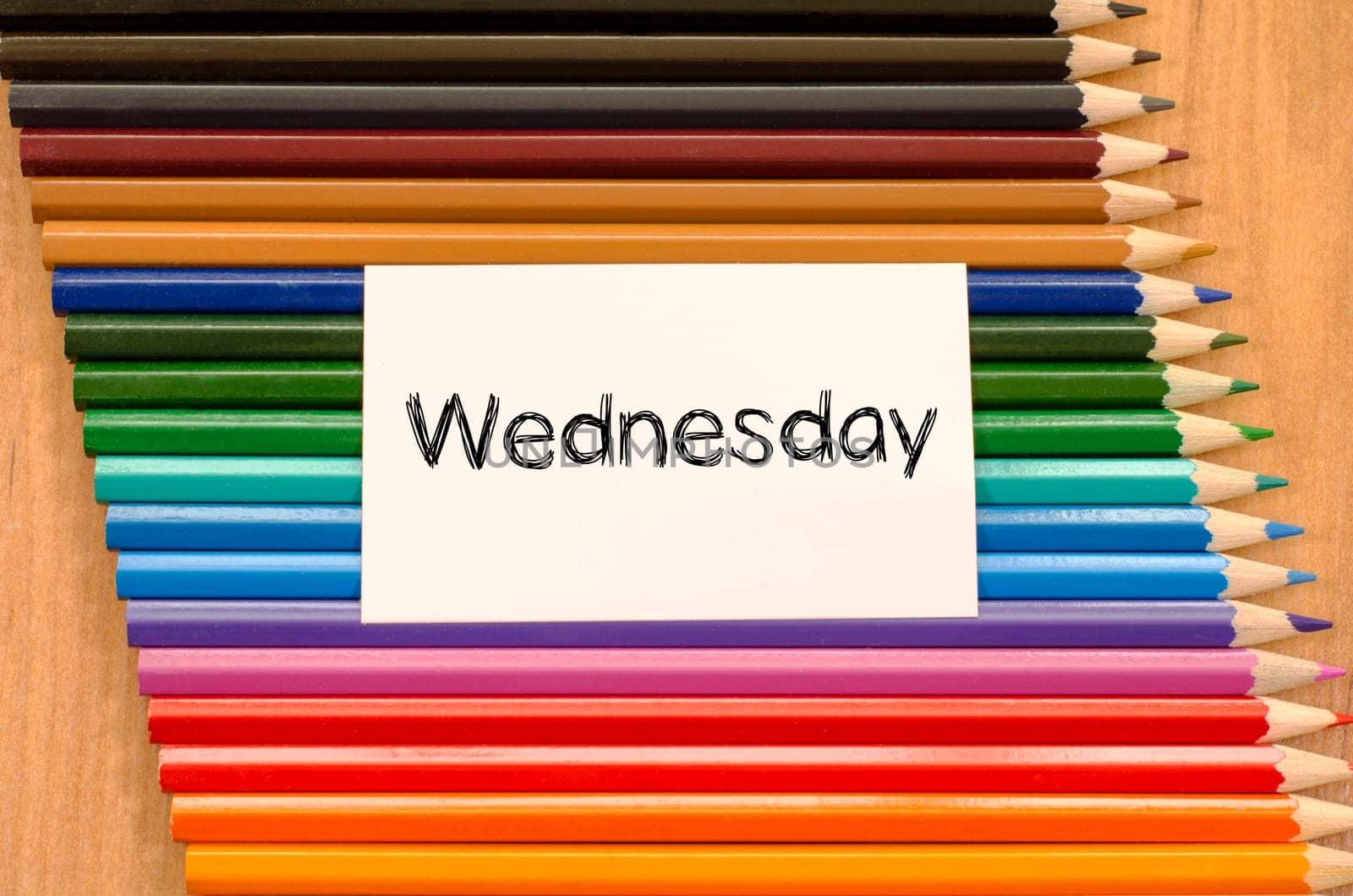 Blank white paper and colored pencils on wooden background