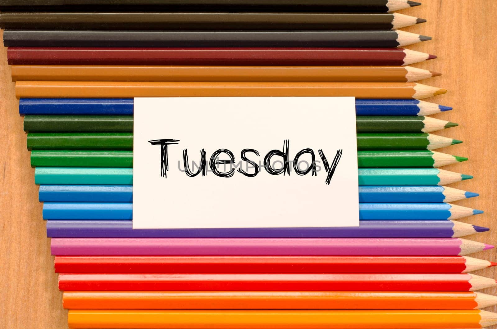 Blank white paper and colored pencils on wooden background