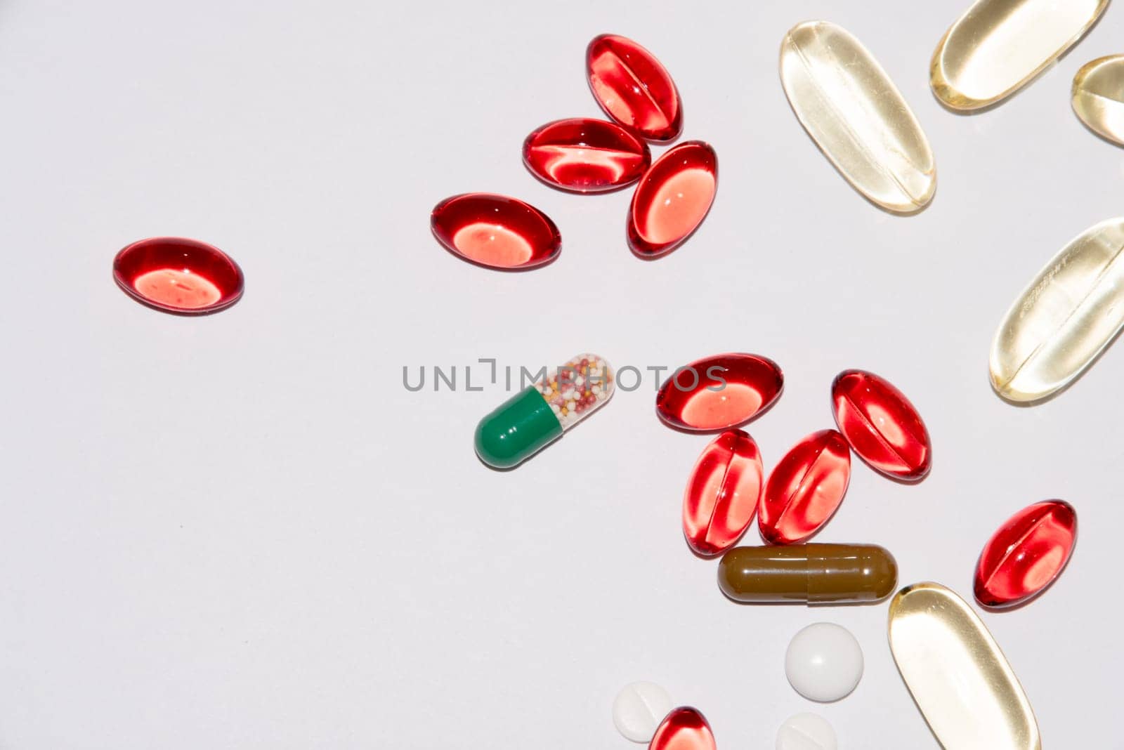 Tabs Vitamins, omega 3, Medications tablets and capsules in a beaker. Medications tablets, suppository bottles, capsules and thermometer on wooden table