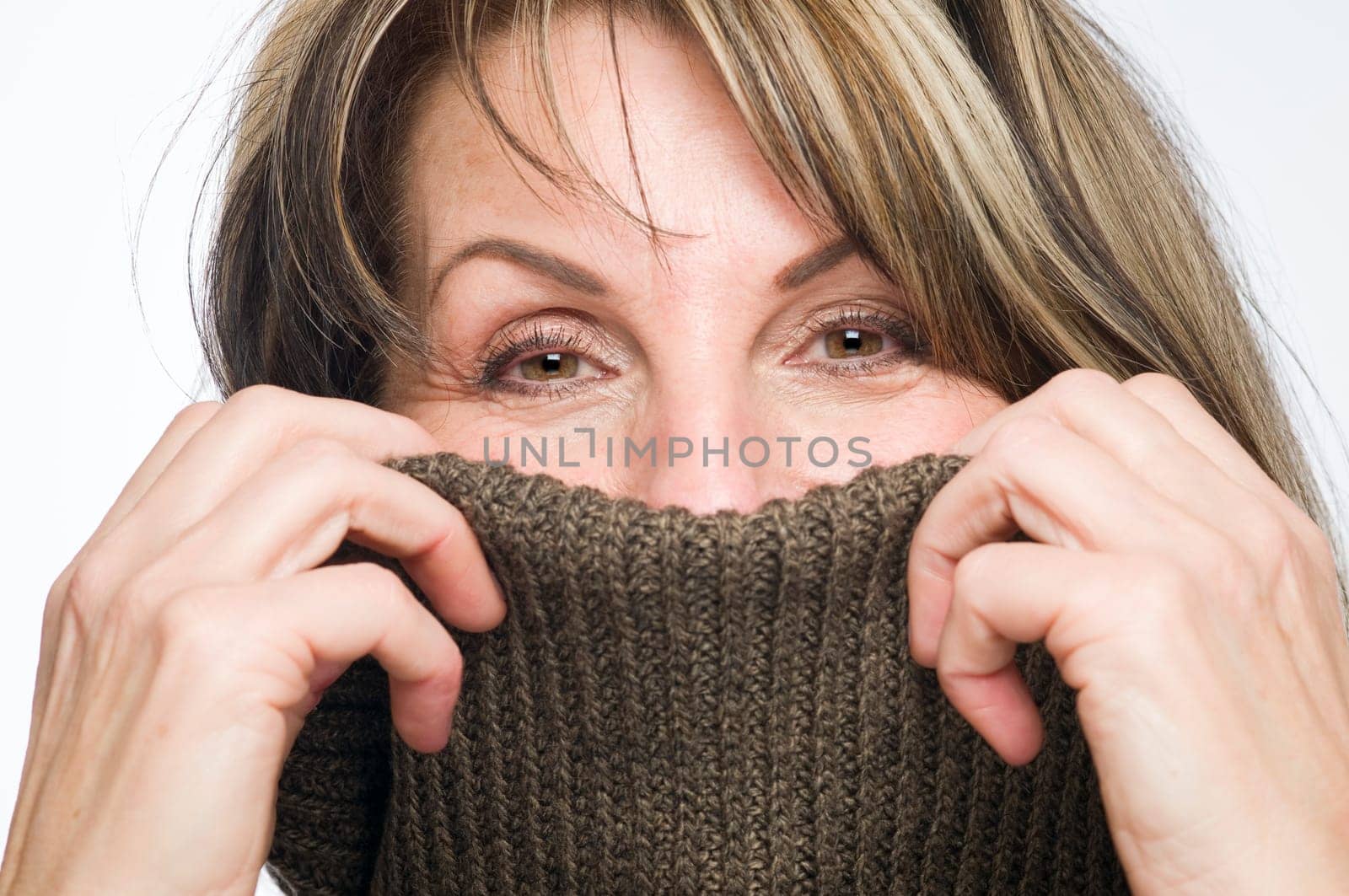 Frontal close up of a middle-aged woman with a turtlenut pulled over her nose