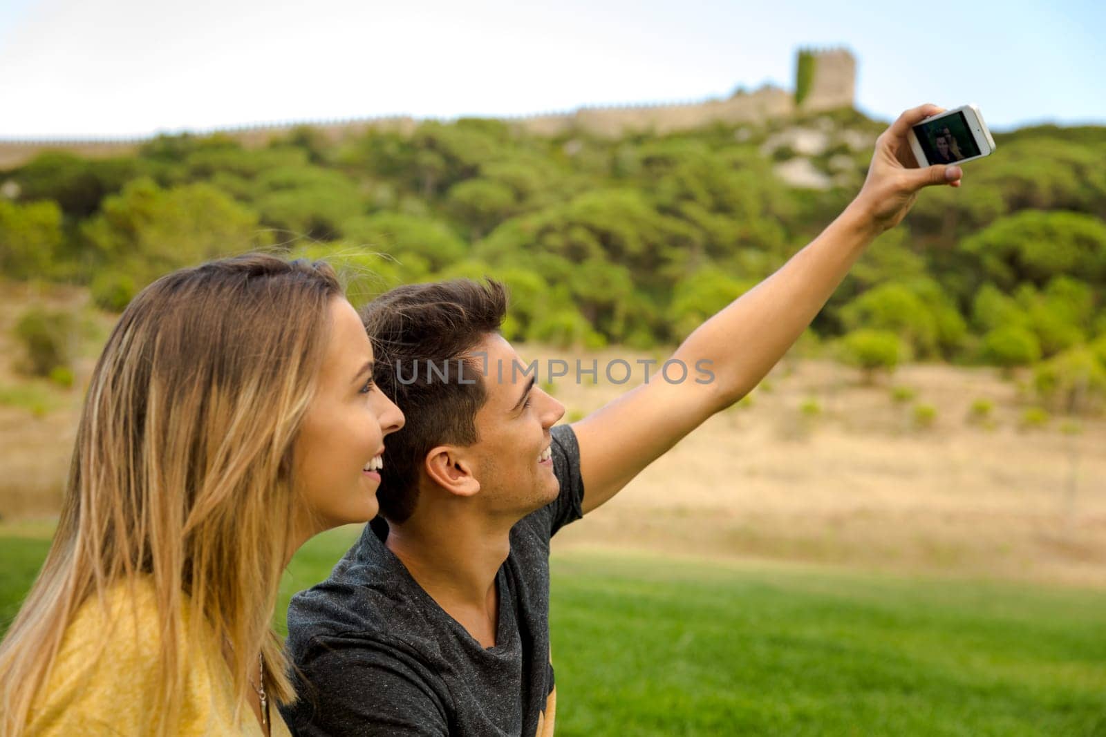 Portrait of a young beautiful couple lying on the grass