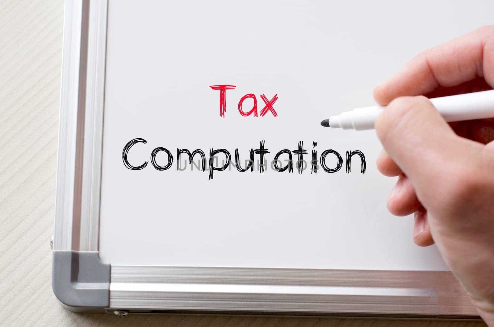 Human hand writing tax computation on whiteboard