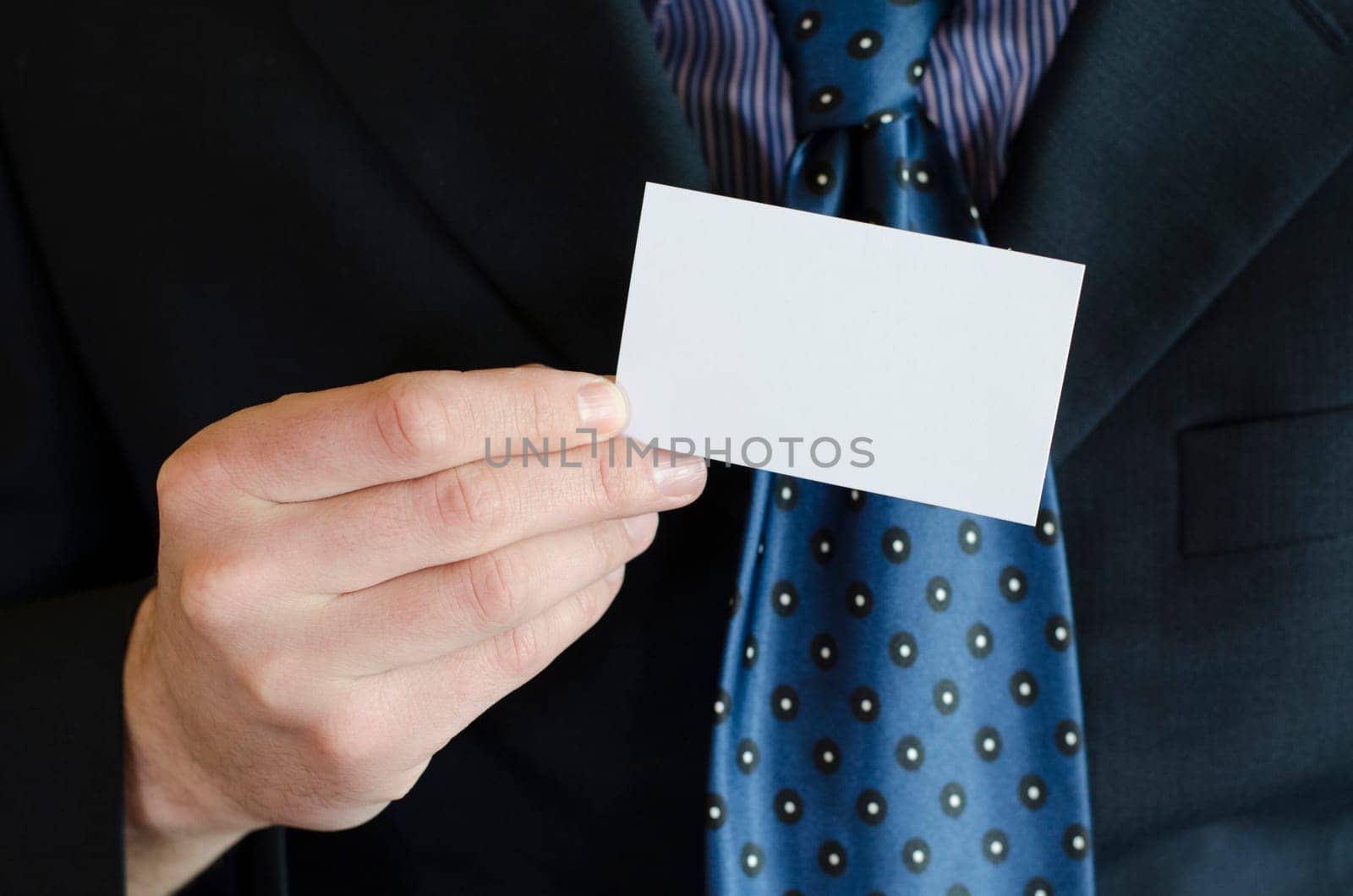Business man hand holding white empty note..