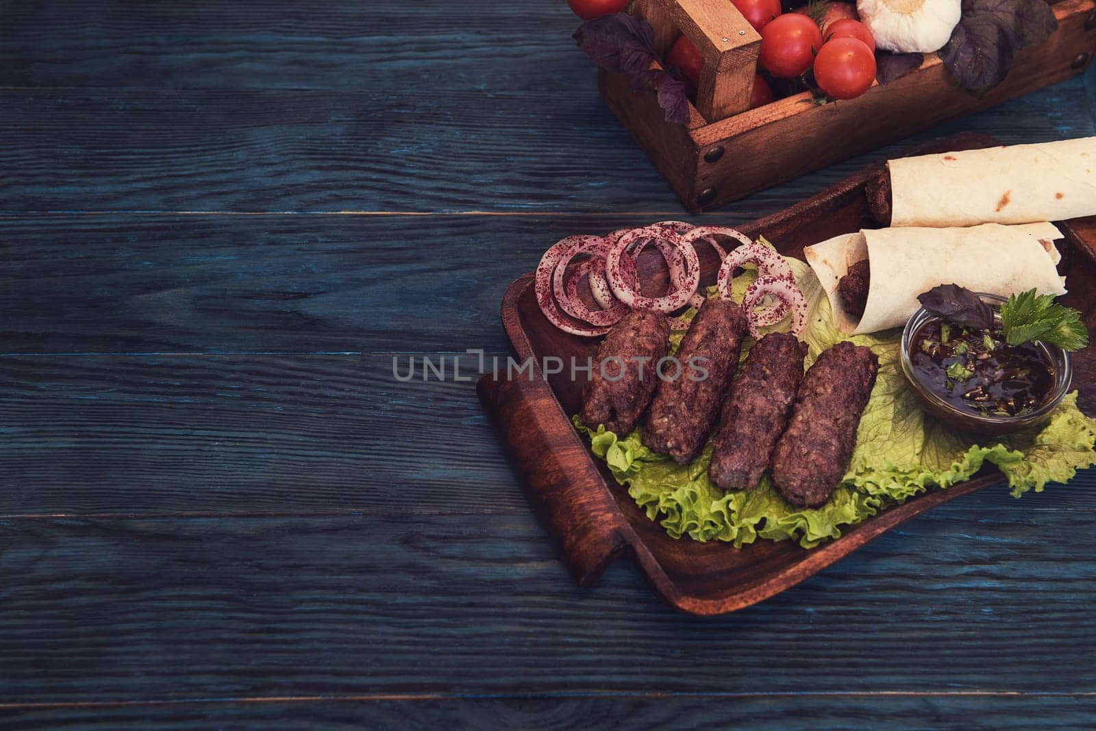Grilled lula kebab - meat dish, with vegetable on a blue wooden background