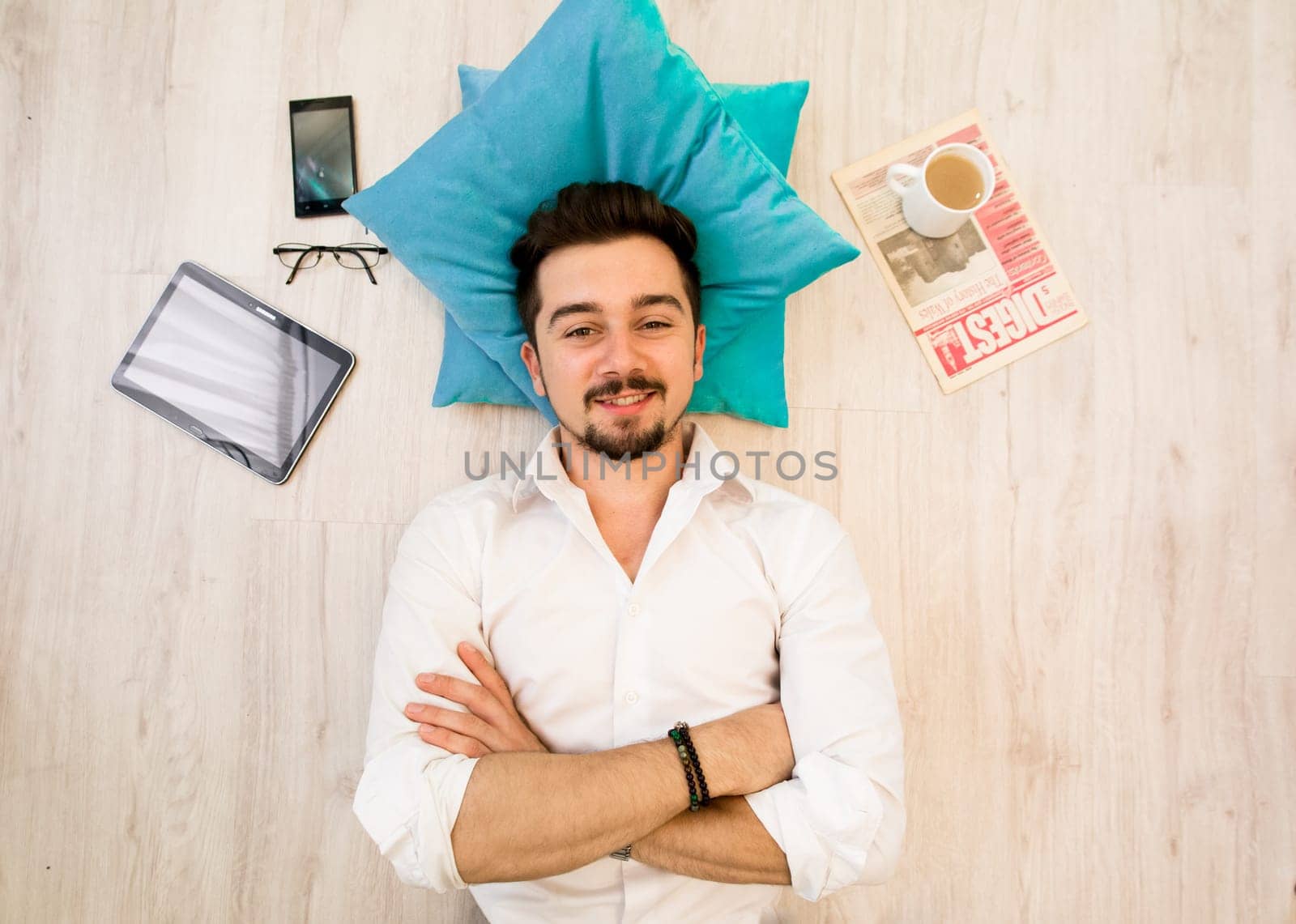 Relaxed man lay on the wooden floor at home