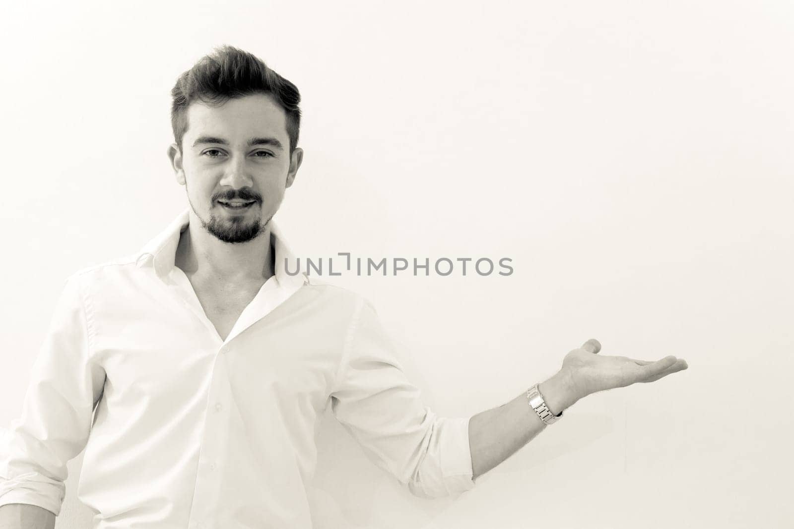 Serious man demonstate with hands something standing against white background